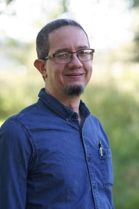 Yan Sang Dominican Republic Country Director in denim shirt against green background