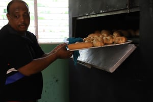 Bread of Hope Taking out bread from oven
