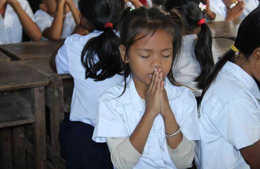 Girl praying at floating school