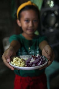 Lalyn helps by chopping the garlic ang onions for the pancit bihon