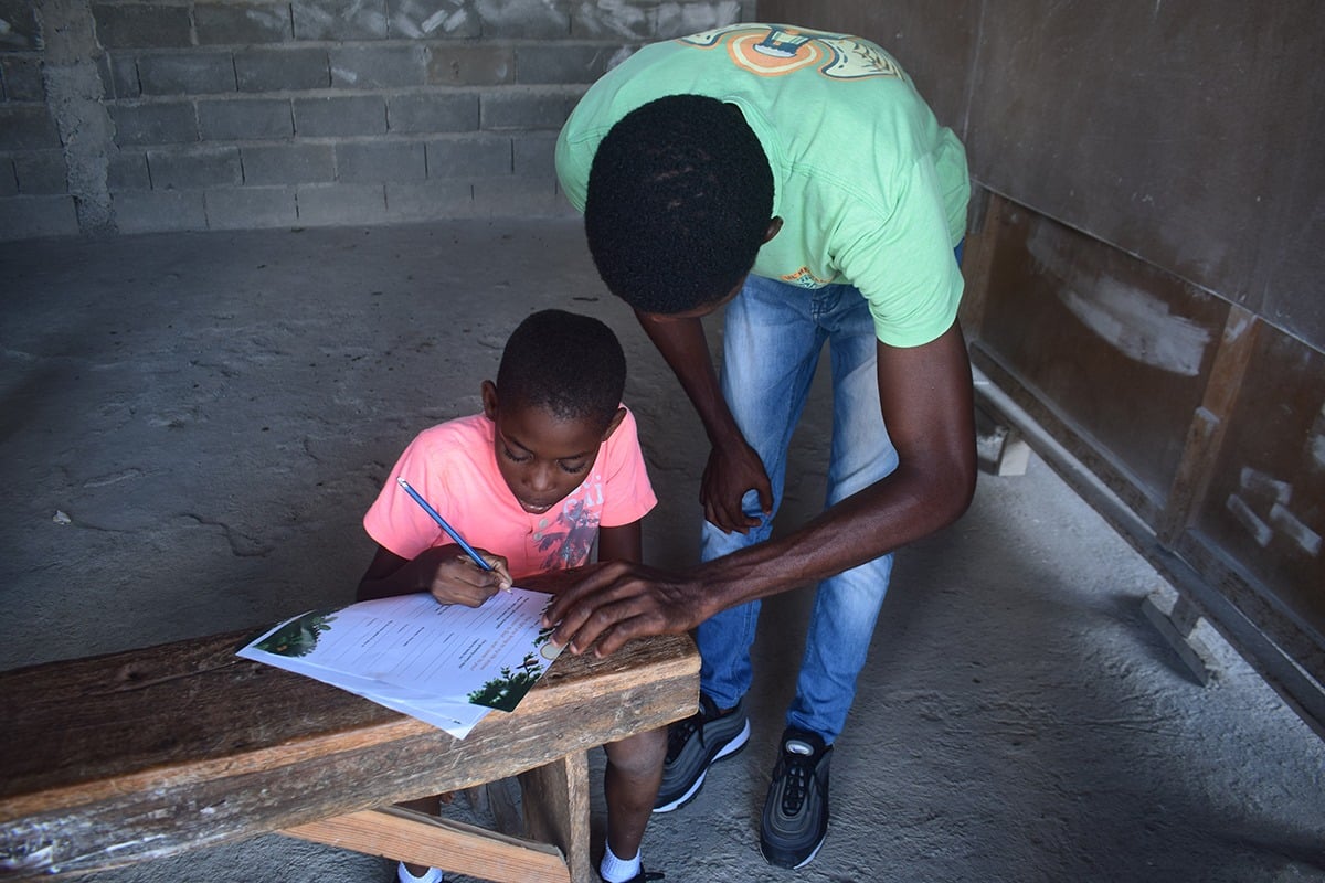 A Child Champion helping a student write a letter